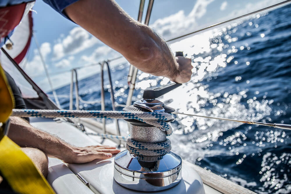 Hands securing rope on a sailing boat.