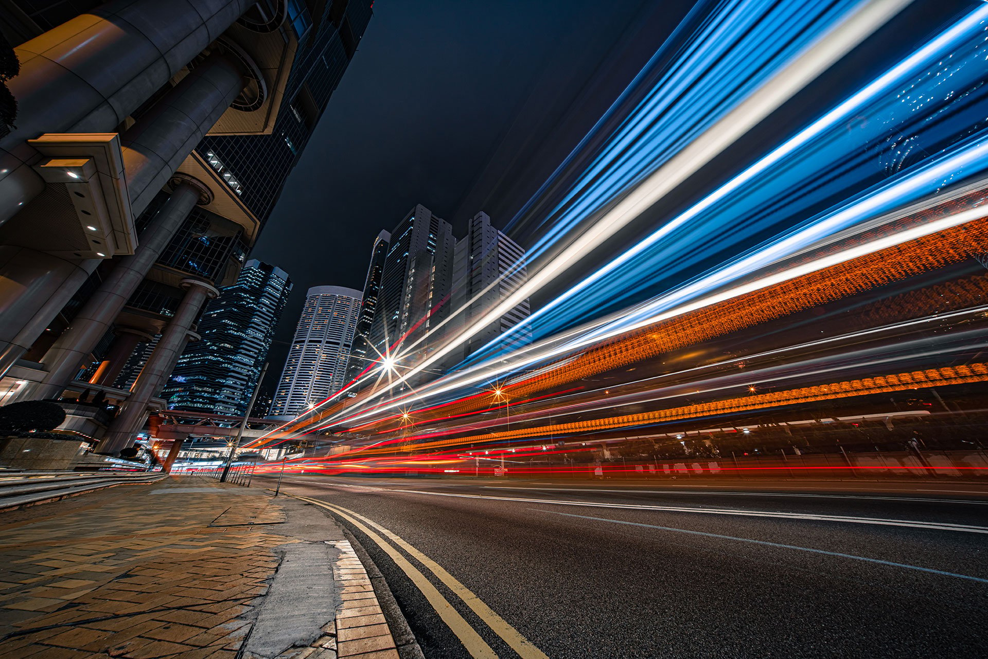 Eine dunkle Straße, die von Autoscheinwerfern beleuchtet wird.