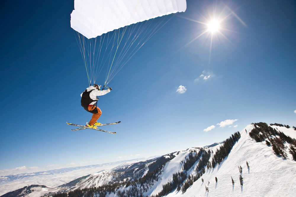 A skier paragliding towards a mountain