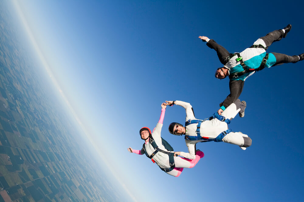 Three paragliders jumping together 