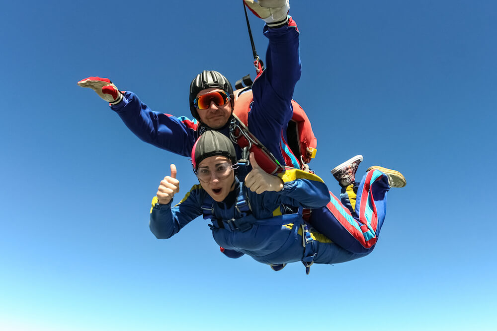 An assistated parachute jump, the client is showing thumbs up. 
