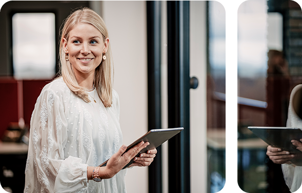 Frau mit Tablet steht in einem modernen Büro.