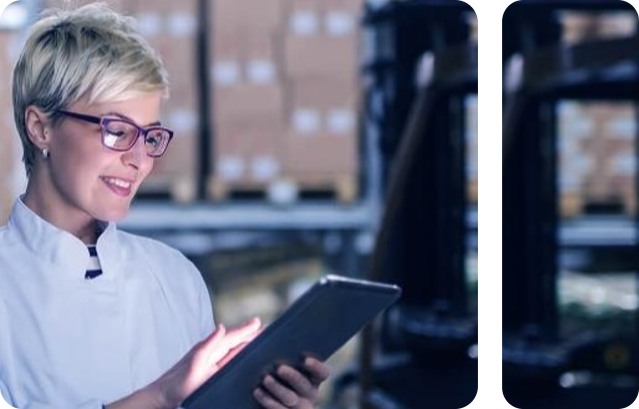 Person in lab coat looks at tablet and smiles