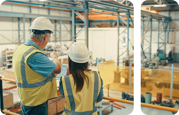Two engineers in a modern production hall, talking to each other.