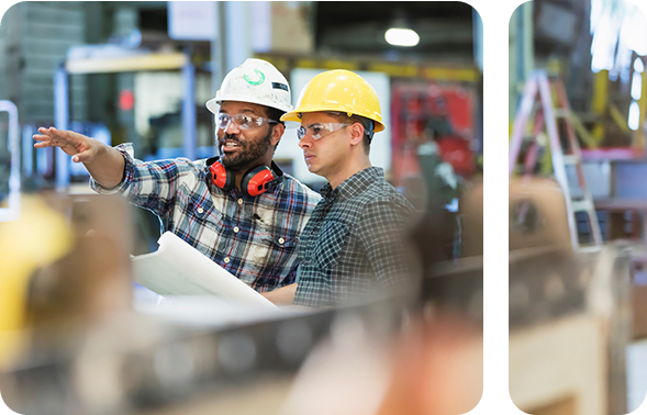 Two workers in a production hall talking to each other