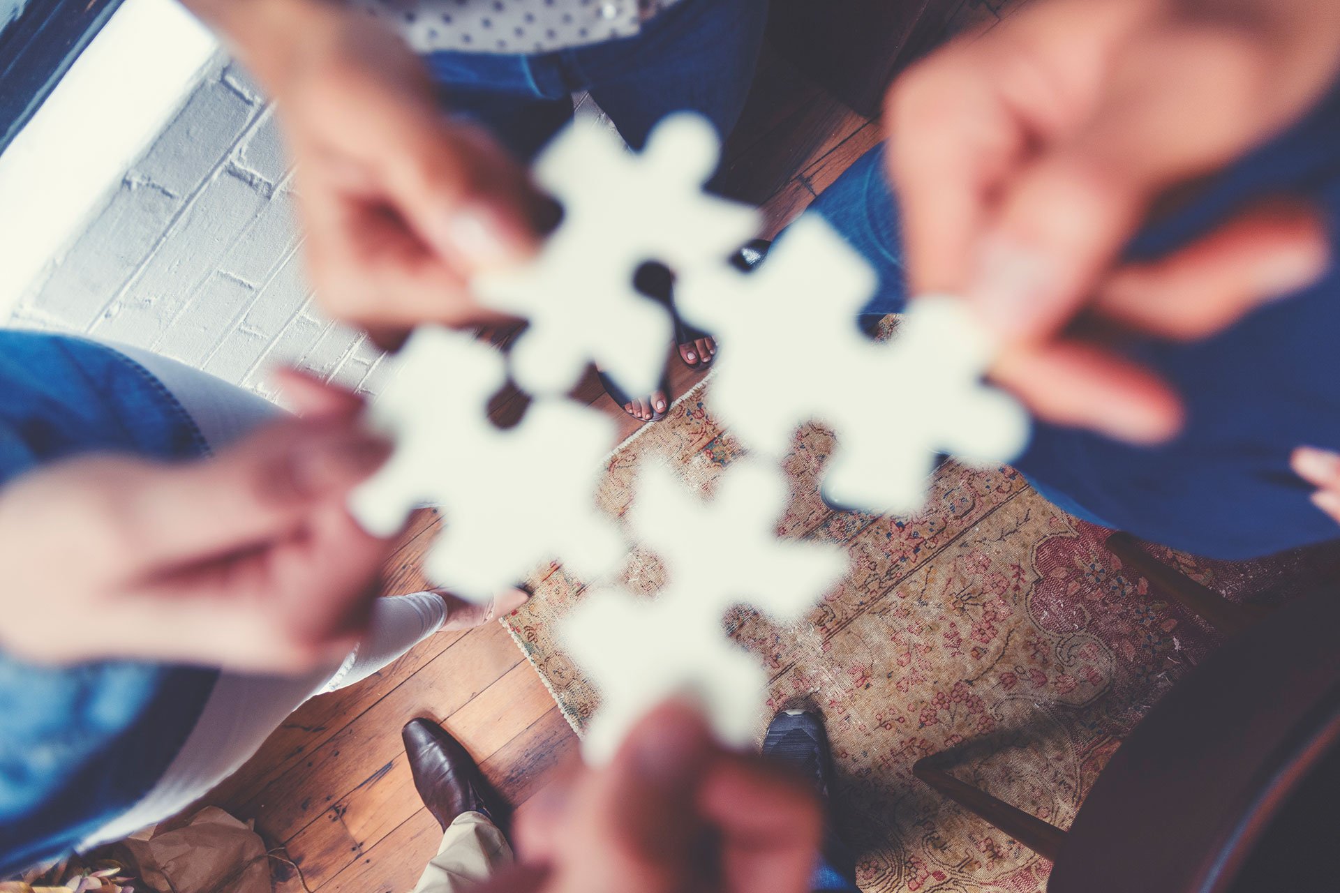 People holding puzzle pieces together
