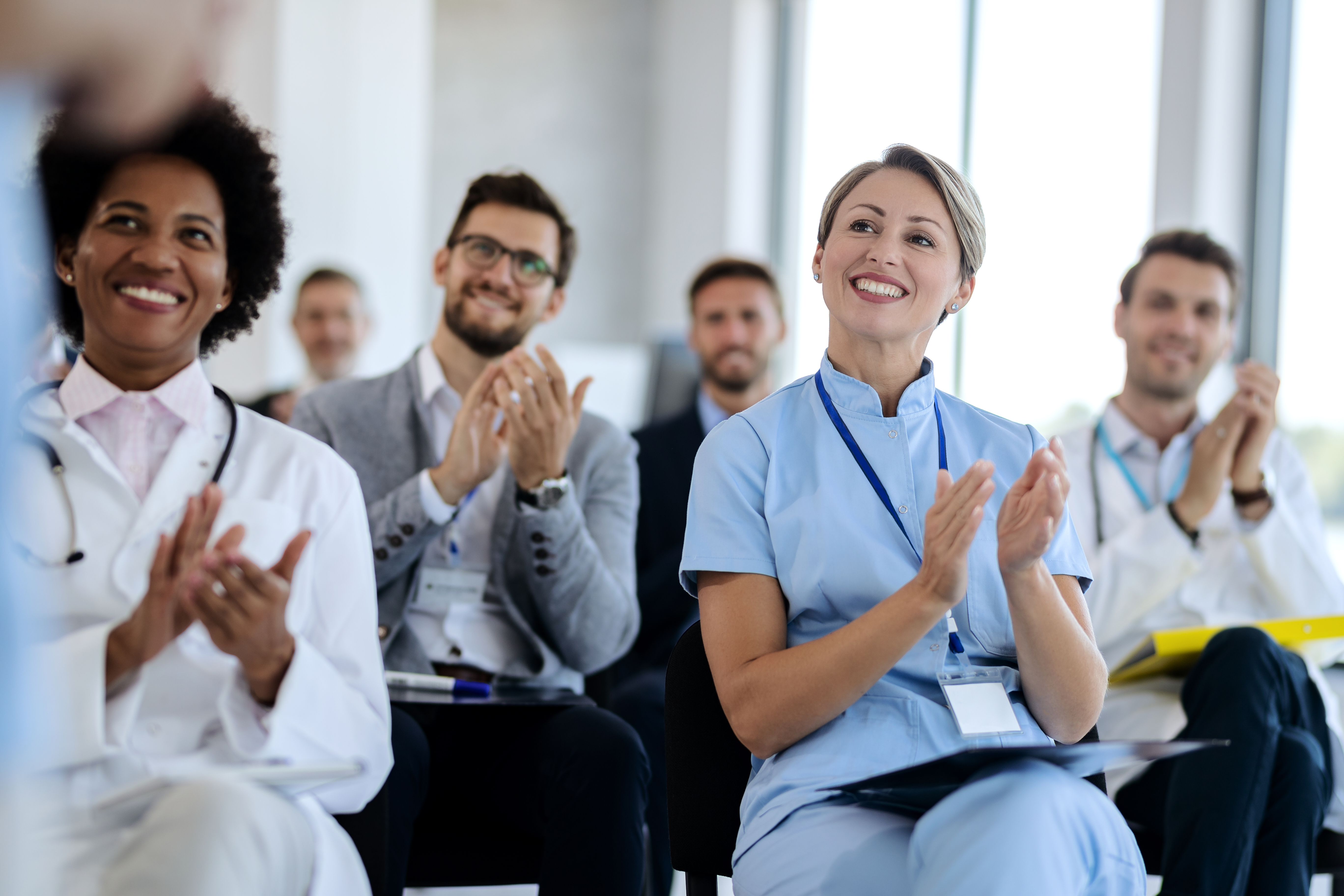 group-of-happy-healthcare-workers-applauding-while-2024-12-13-17-26-20-utc